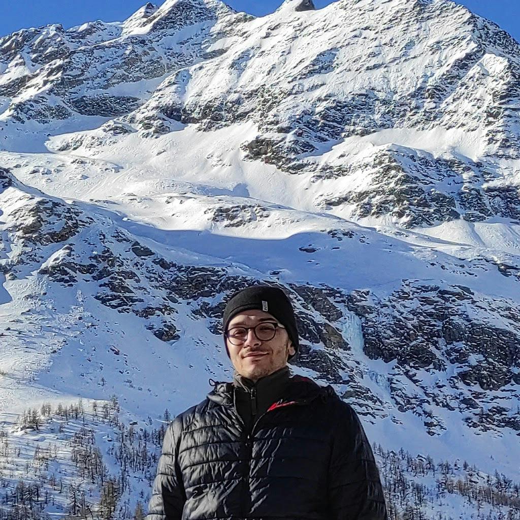 Arda Sevinc profile picture, standing before the swiss alps